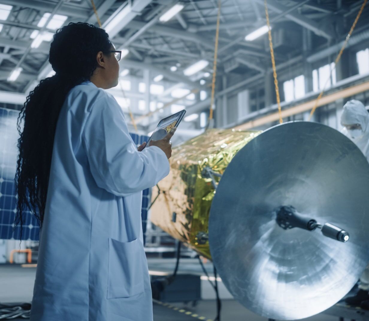 Woman holds a computer in a warehouse - Applied CAx Siemens software partner USA