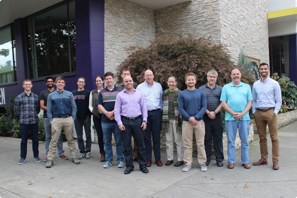 Group of 14 people smiling standing outside a building - Applied CAx Siemens software partner USA
