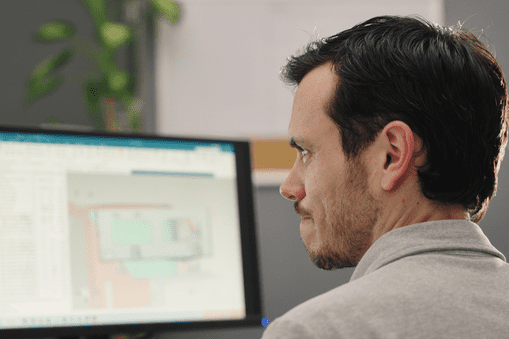 Man looking at a computer screen with NX CAD on the screen - Applied CAx Siemens NX software