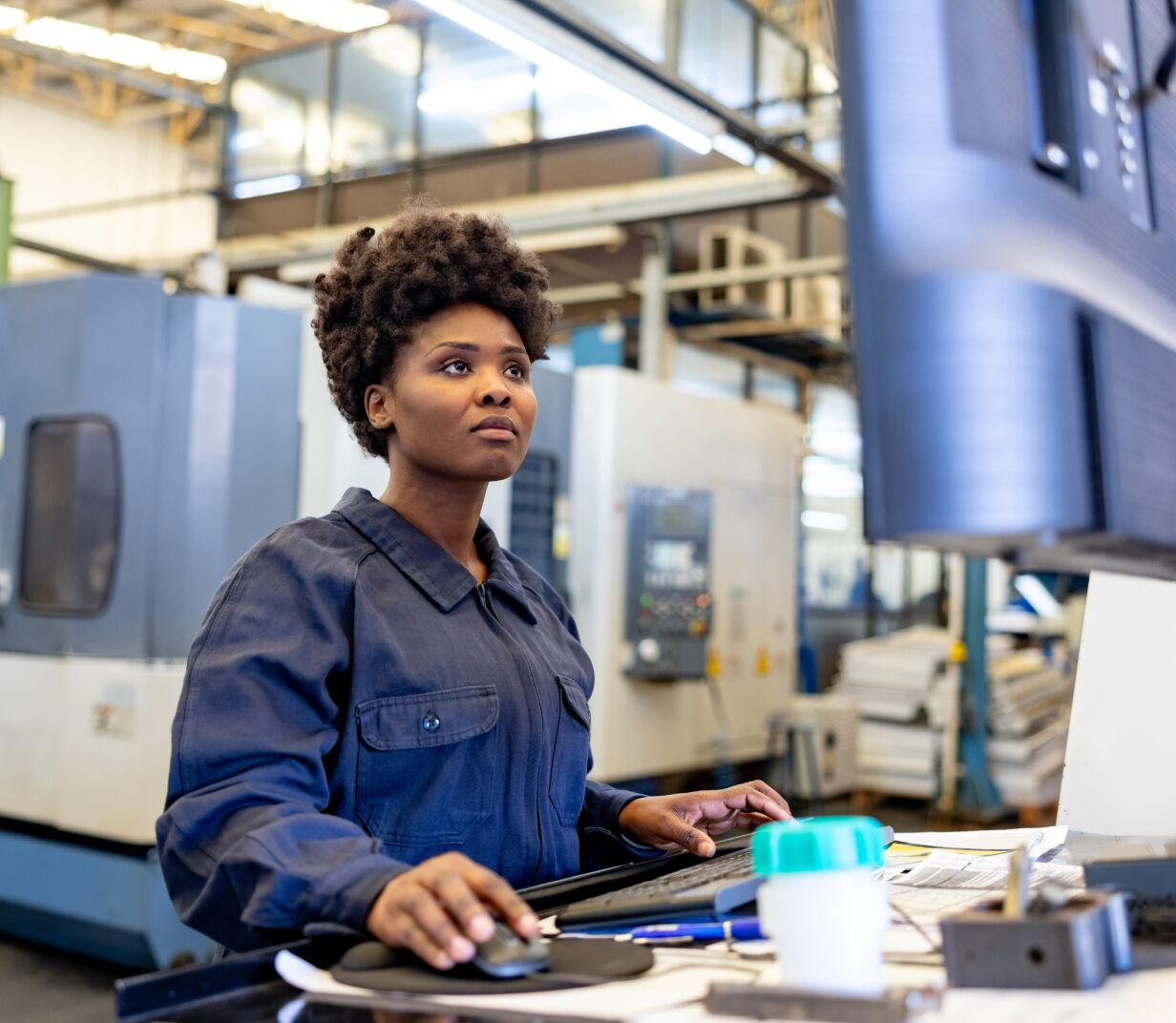 Woman works on a computer in a warehouse - Applied CAx Siemens software partner USA